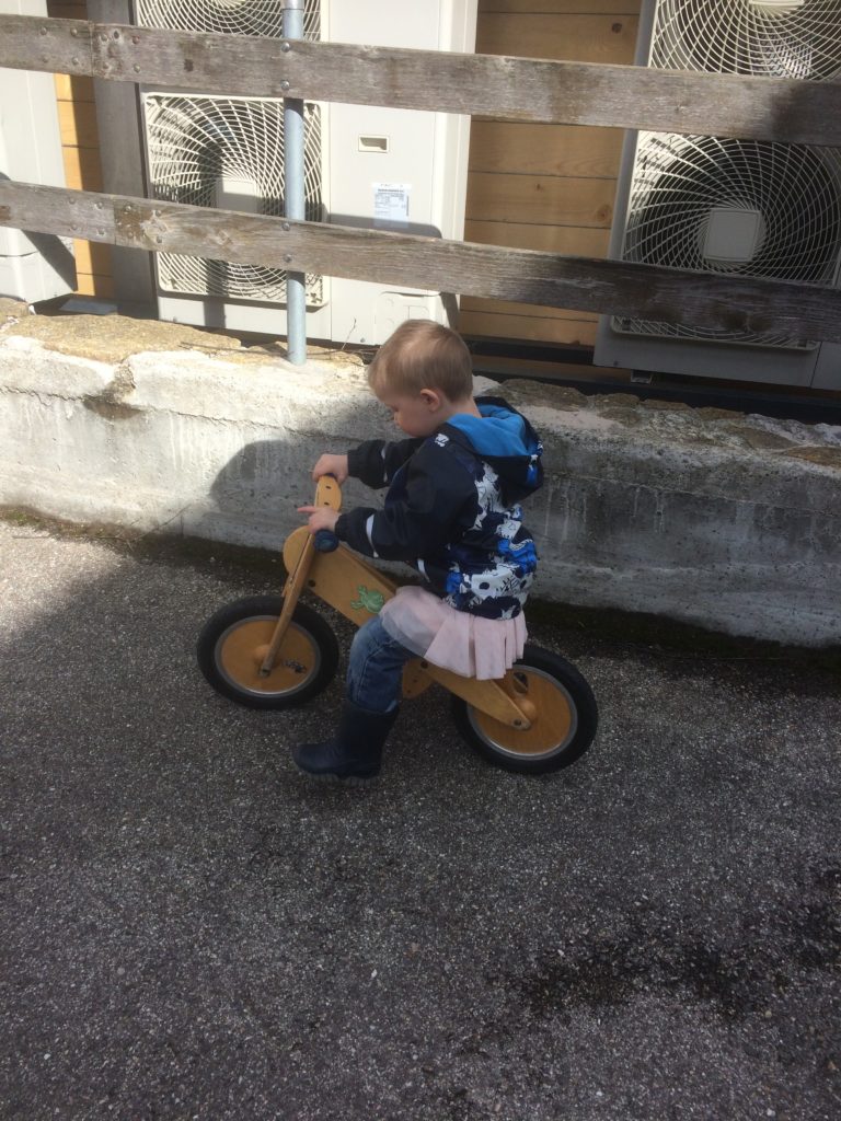 Notre fils Kalen en jupe sur son vélo devant la maison