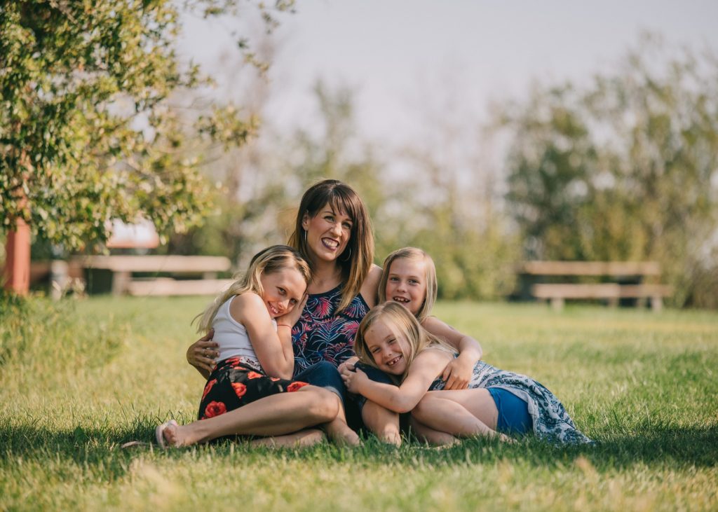une maman avec ses filles sur l'herbe
