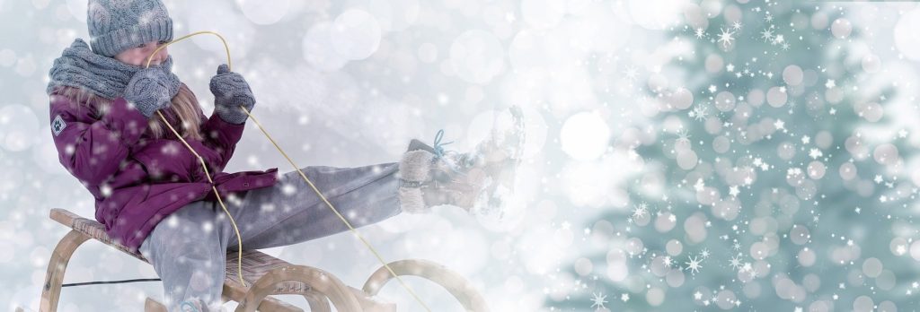 enfant sur une luge, paysage d'hiver