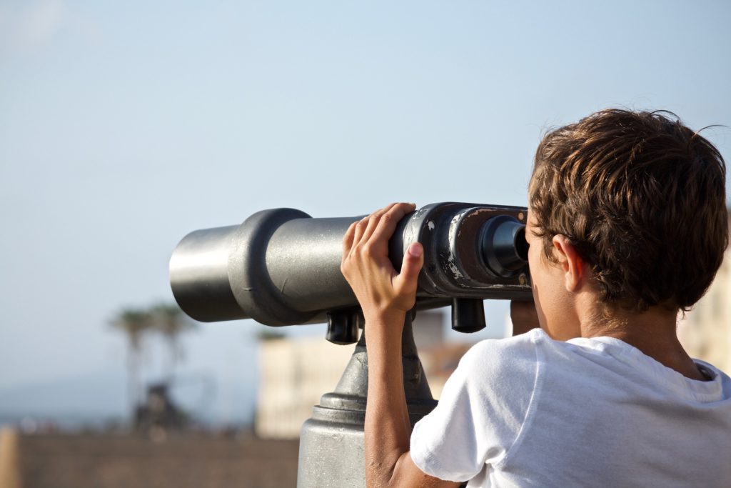 enfant qui observer le paysage avec des grandes jumelles