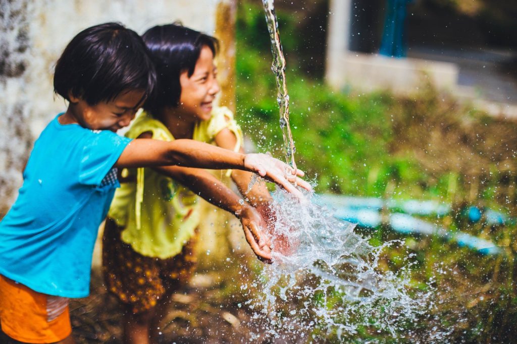 deux enfants heureux de jouer avec de l'eau