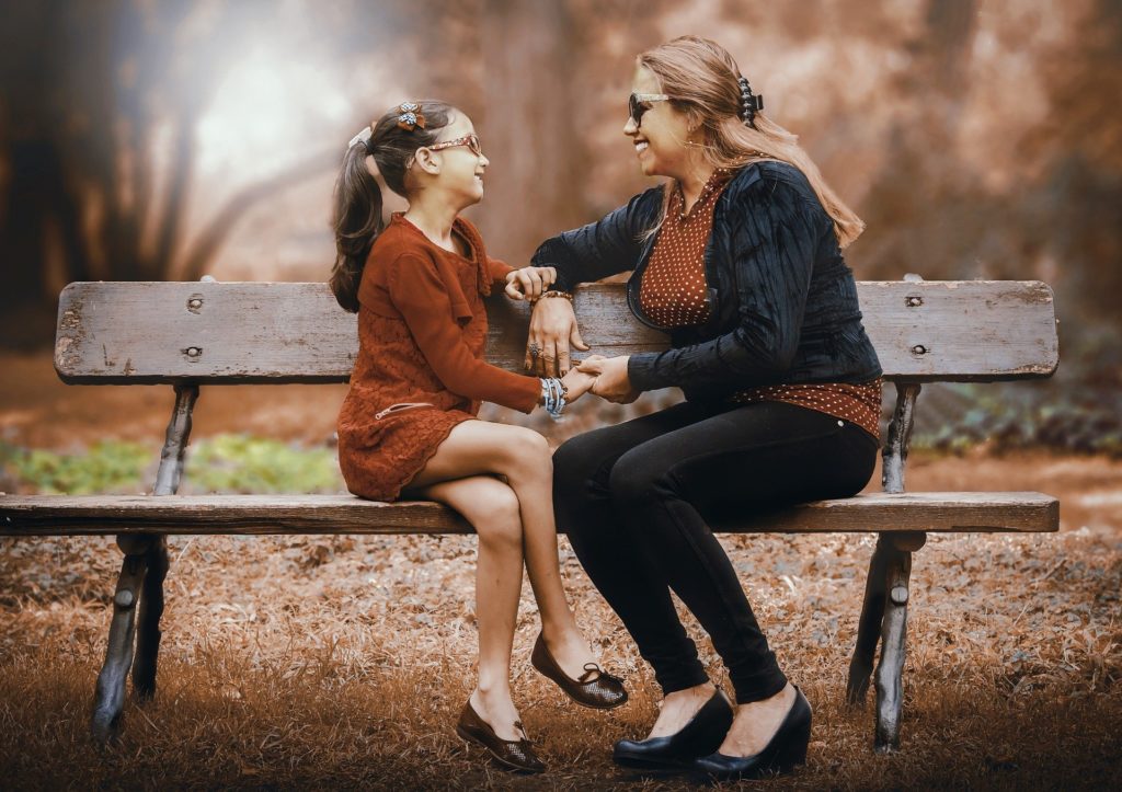 une mère et sa fille discutant sur un banc