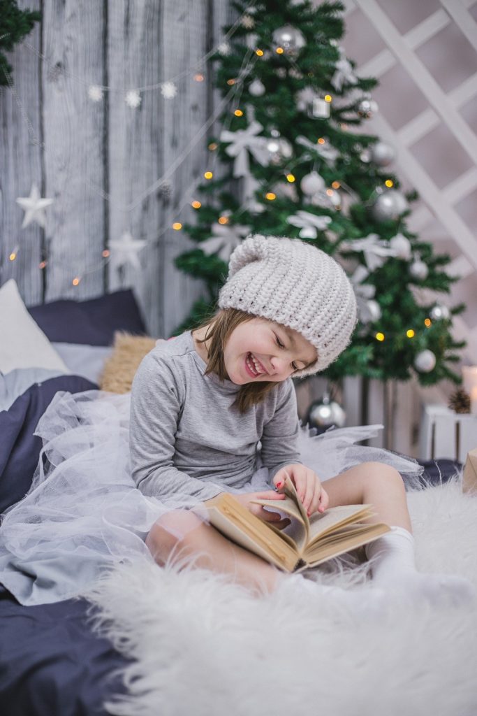 petite fille lisant un livre pour attendre noel